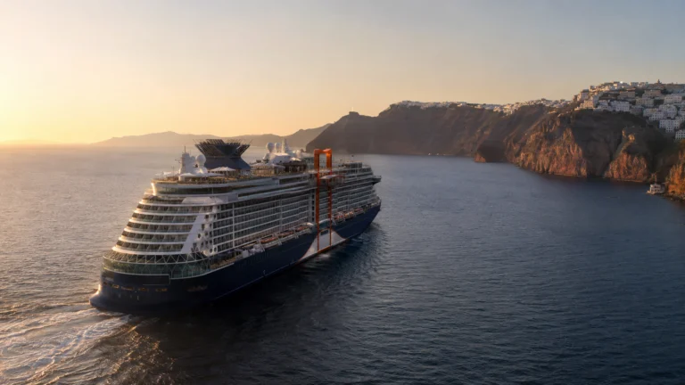 Celebrity Beyond sailing past coastal cliffs at sunset