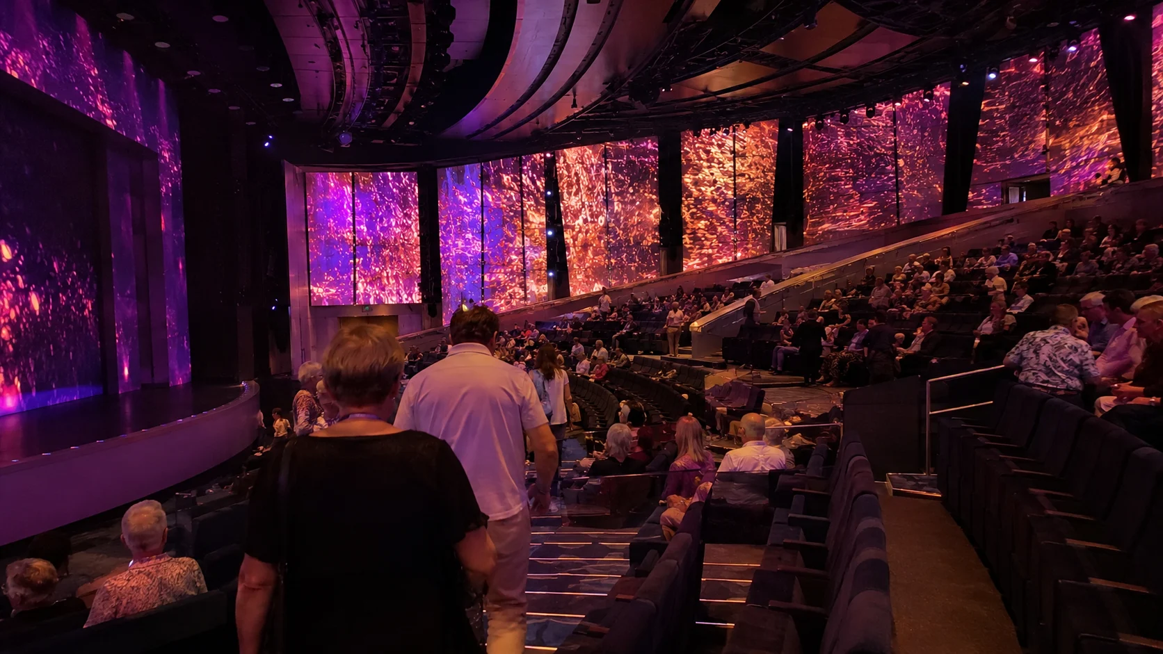 Audience watching a colorful show in the Celebrity Edge Theatre
