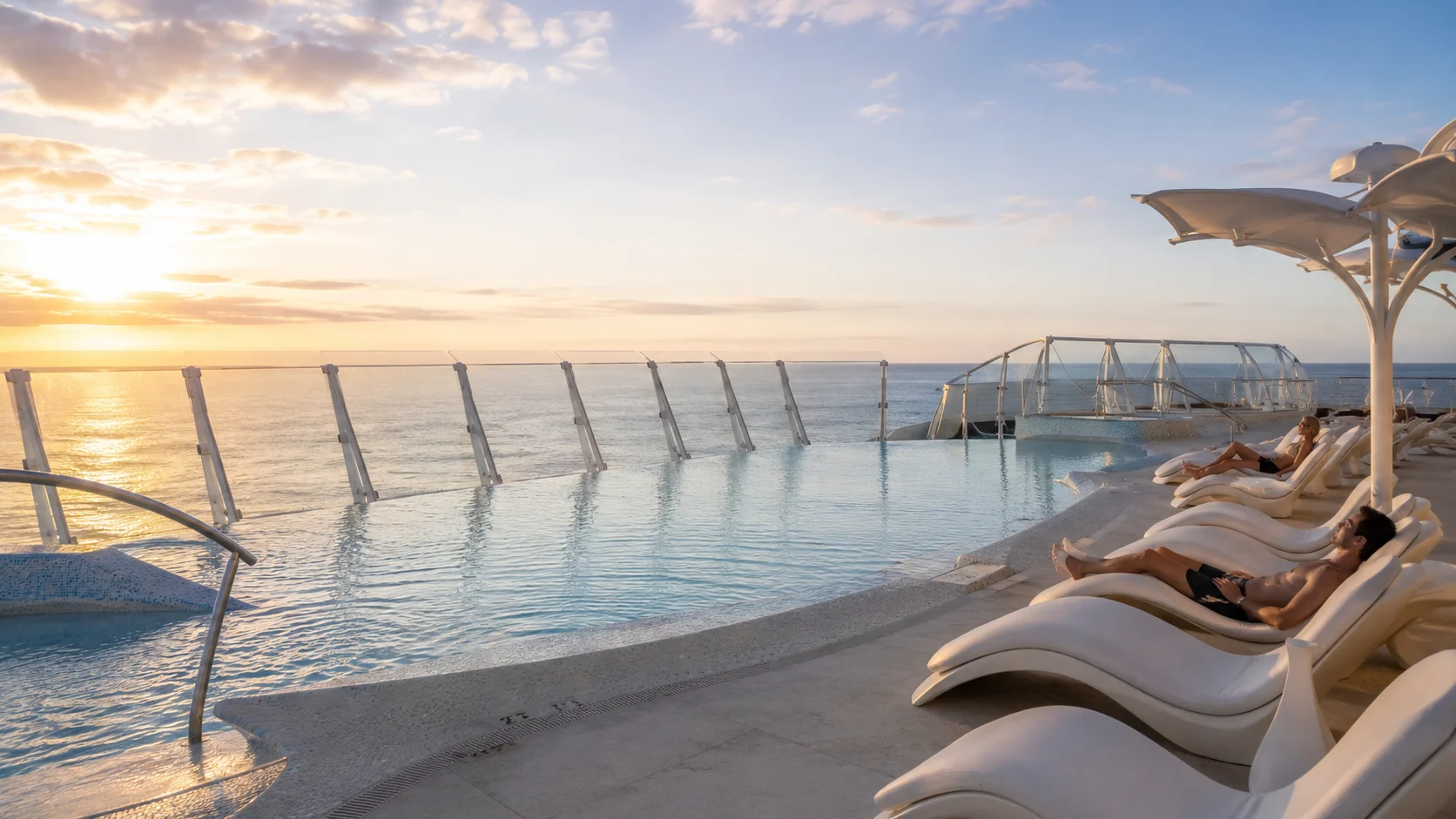 Quiet Cove infinity pool and loungers aboard Disney Destiny at sunset