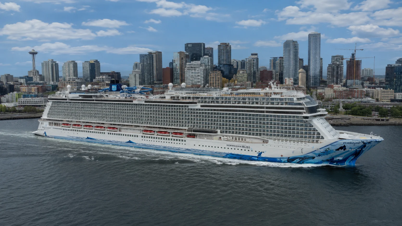 Norwegian Bliss sailing near a coastal city