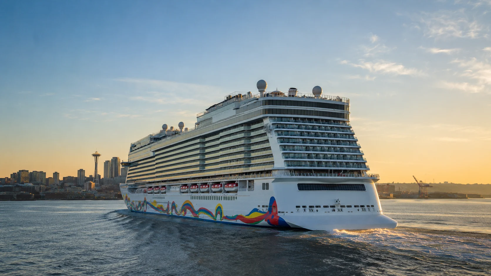 Norwegian Encore sailing near a city skyline at sunset