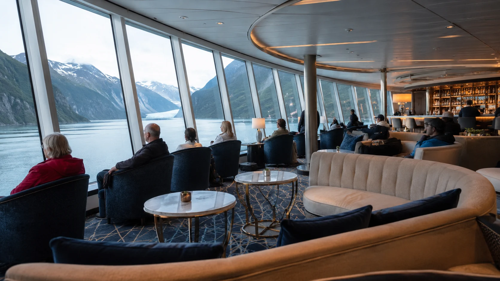 Passengers relaxing in the Norwegian Encore Observation Lounge