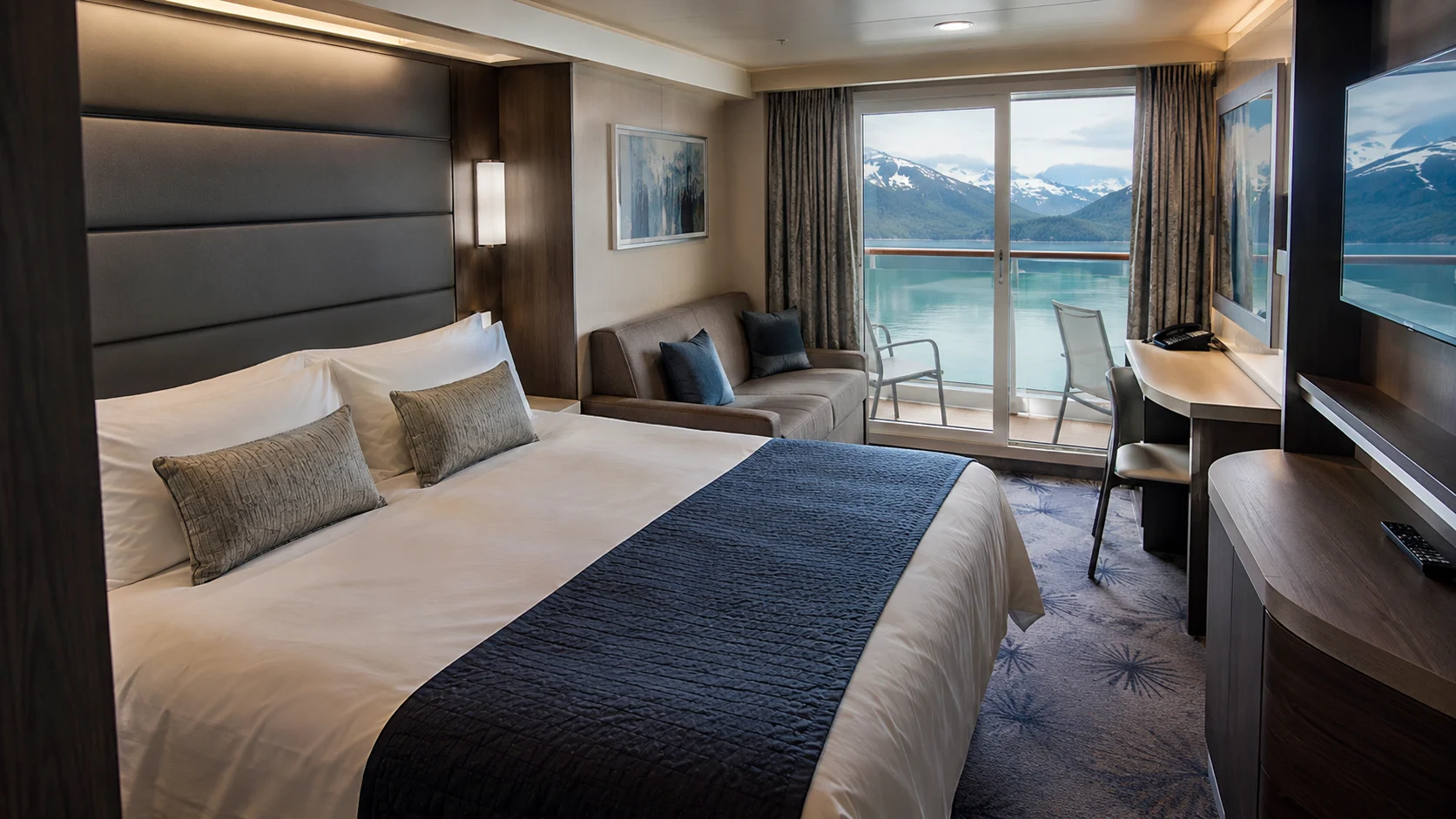 Norwegian Encore balcony cabin with a double bed and sofa