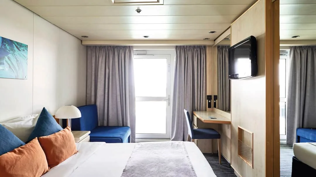 Representative Marella Voyager standard Balcony cabin with a bed and sofa
