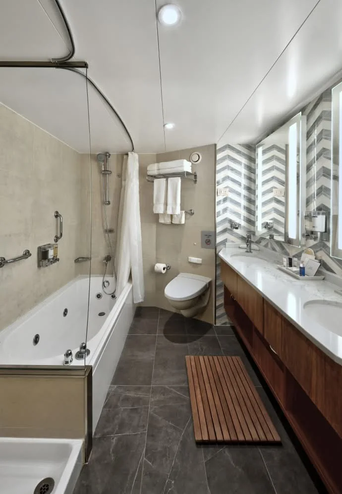 Representative Nieuw Amsterdam Neptune Suite bathroom with dual sinks and a bathtub